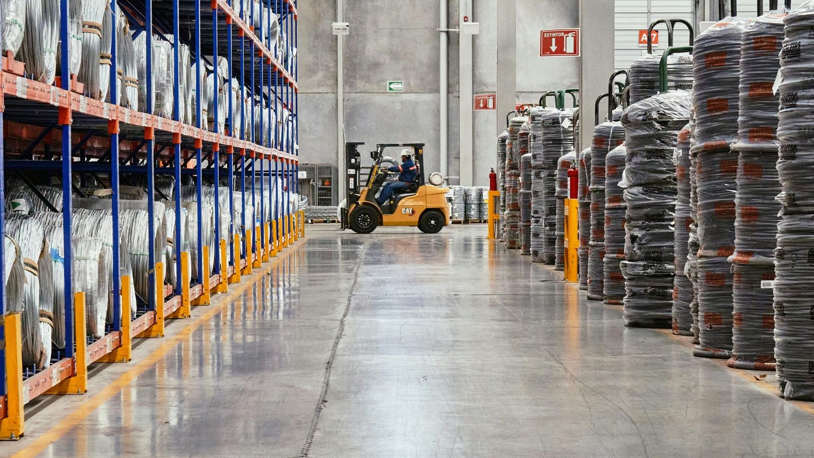 Coiled cable stock racked in a supply warehouse, forklift in the aisle