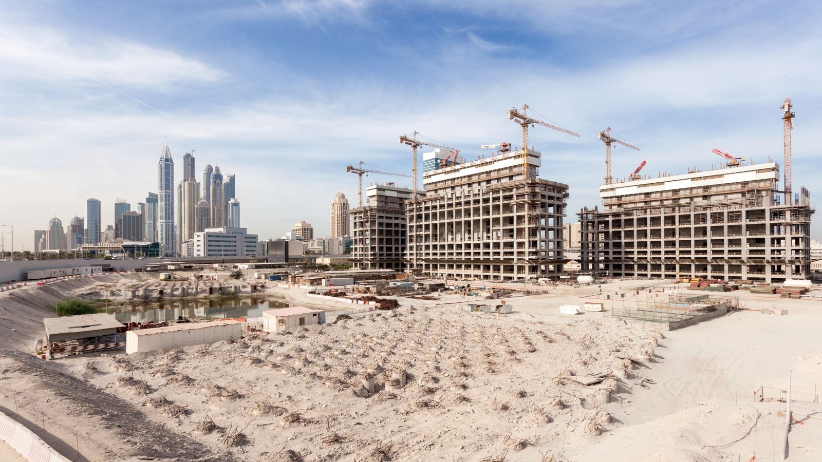 Towers under construction against the Dubai skyline